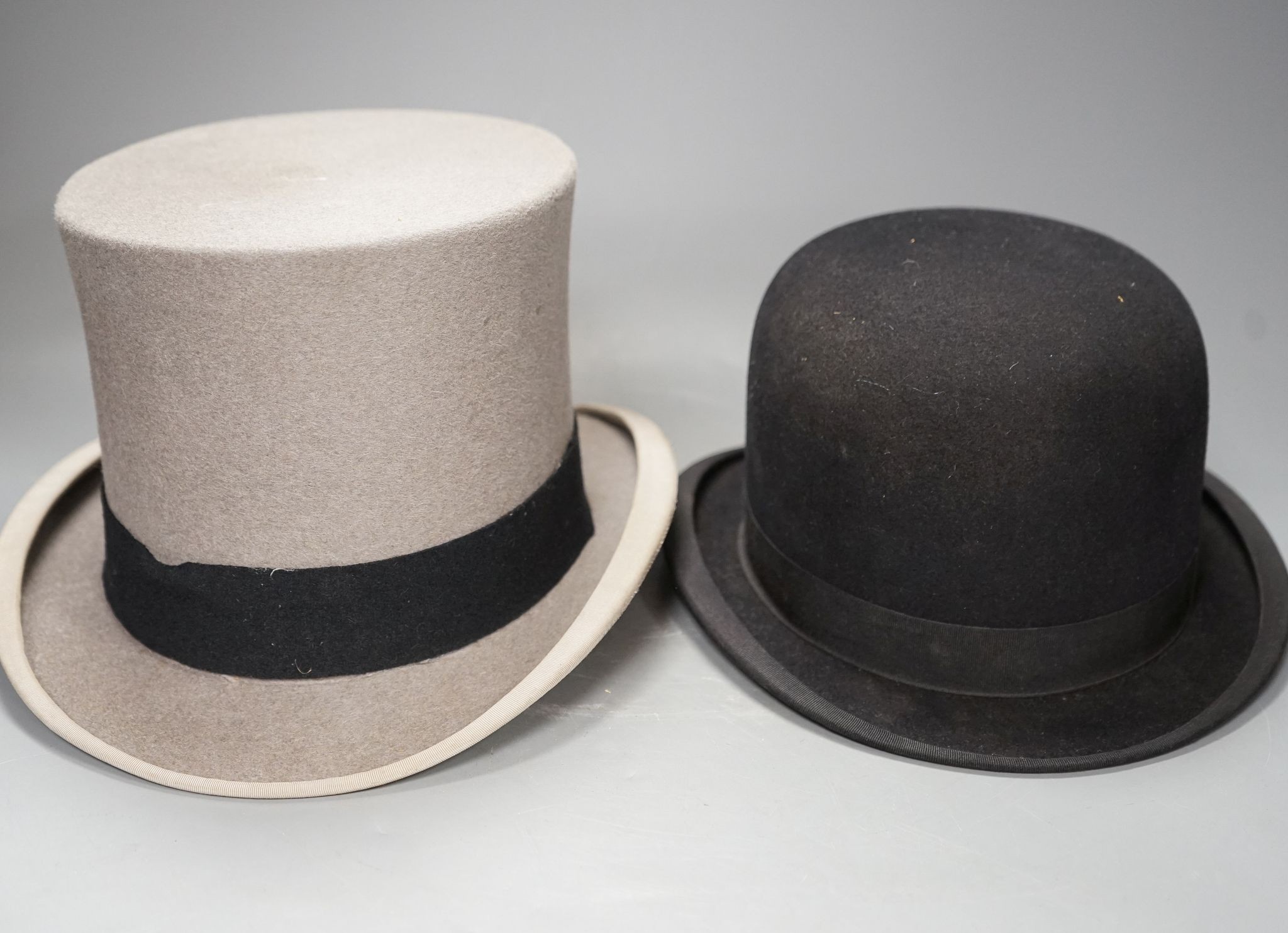 An Army & Navy Stores Ltd. grey top hat and a Christys of London black riders bowling hat, both boxed